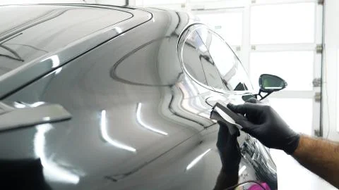 Close up to PPF installation process on a front headlight and hood. Stock Photos