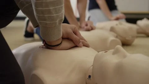 Close up practicing chest compression on dummy in EMT first aid training Stock Footage 168654044