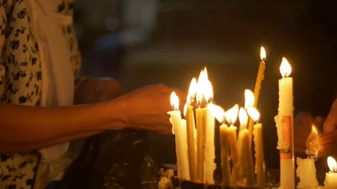 Close up of prayers hands lighting candles in the Holy Sepulchre Church in 스톡 동영상 70719162