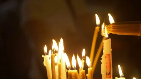 Close up of prayers hands lighting candles in the Holy Sepulchre Church in 스톡 동영상 70719924