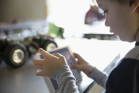 Close up pre-adolescent boy programming robotics at digital tablet 스톡 사진