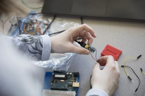 Close up pre-adolescent girl assembling electronics Foto stock