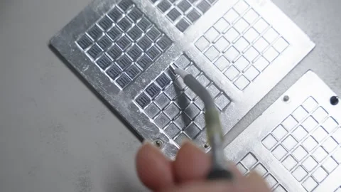 Close-up of precision assembly on metal grid plates with reflective square Stock Footage 325977071