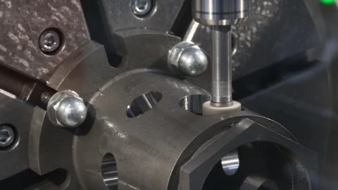 Close-up of precision metalworking machine. Cylindrical metal workpiece rotat Stock Footage 344434524