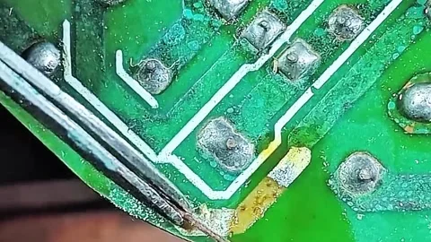 Close-up of Precision Soldering to Restore Broken Circuit Path Stock Footage 333553023