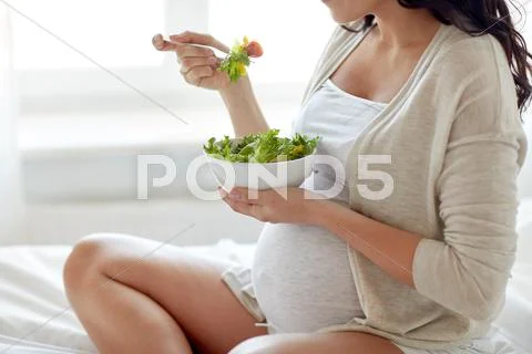 Close up of pregnant woman eating salad at home Stock Photos