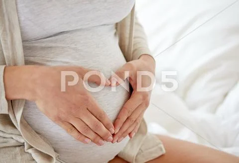 Close up of pregnant woman making heart gesture Stock Photos