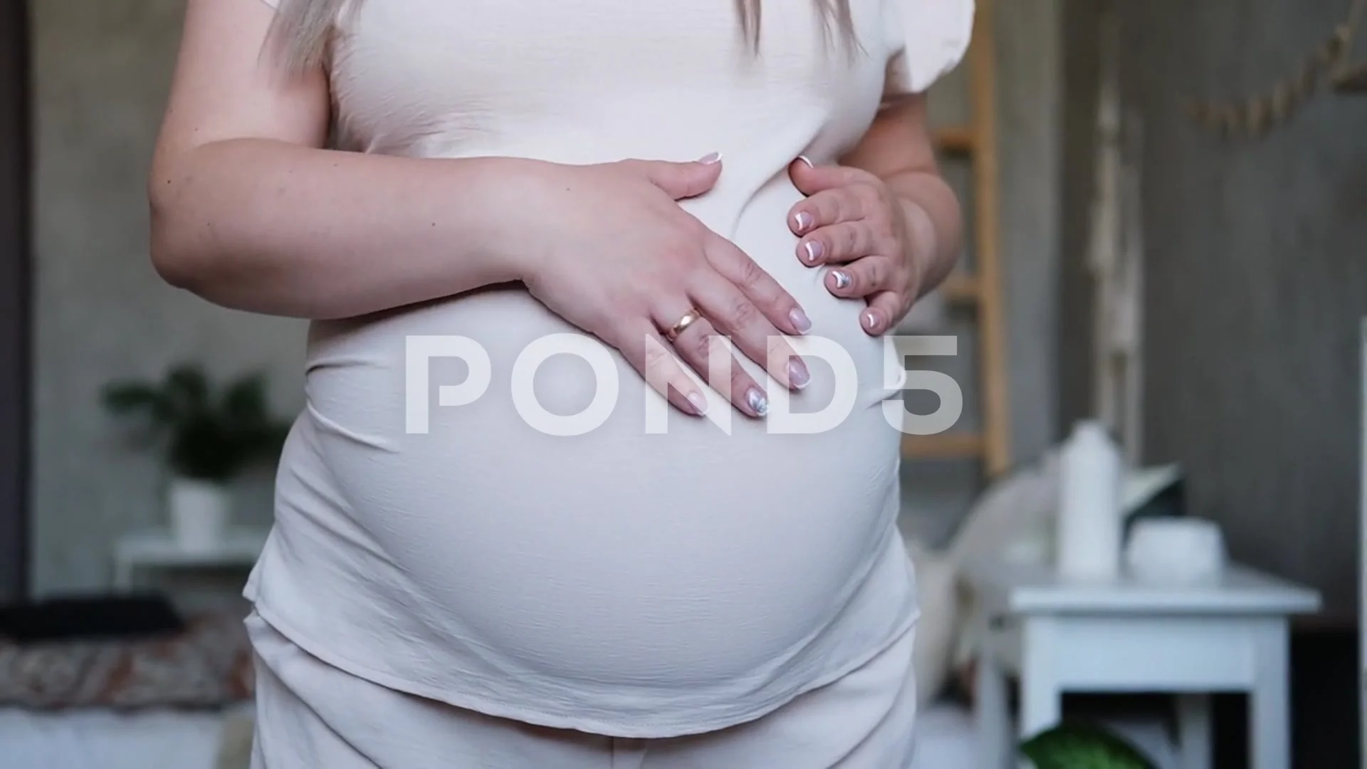 close up pregnant woman strokes her big belly. Maternity prenatal care