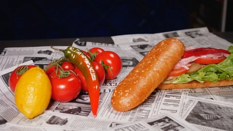 Close-up of a prepared mackerel burger with fresh lettuce, tomato, onion, pepper Stock Footage 128292387