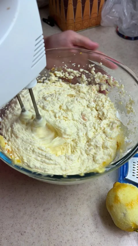 Close-up preparing homemade lemon cake batter using an electric hand mixer in a Vídeos de archivo 346691397