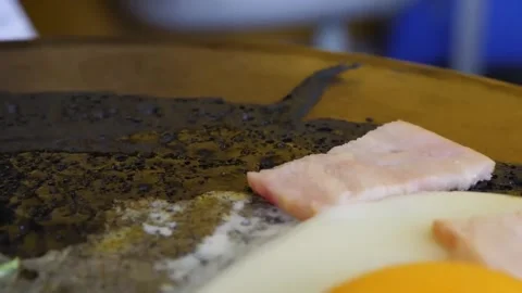 Close-Up of Preparing Savory Breakfast Crepe with Fried Egg and Ham on a Hot Gri Stock-Footage 345692738
