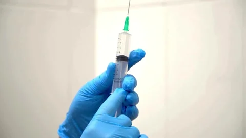 Close up preparing a vaccination to be injected a doctor puts a needle on a Stock Footage 336586990