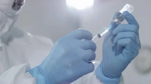 Close up preparing a vaccination to be injected a doctor puts a needle on a Stock-Footage 336587030