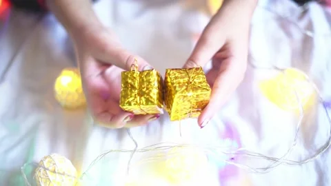 Close-up present boxes in hands ,festive mood and garlands on background. Christ Stock Footage 223854820