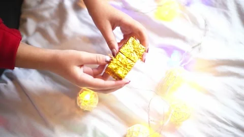 Close-up present boxes in hands ,festive mood and garlands on background. Christ Stock Footage 228258372