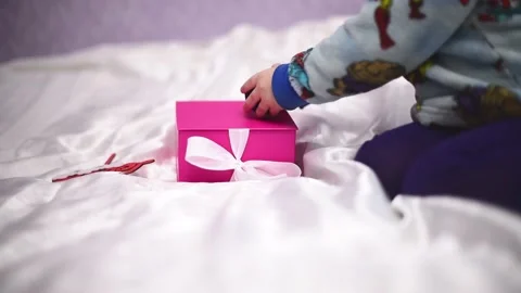 Close-up present pink box and hands of kid playing with blue box with golden rin Stock Footage 229868253
