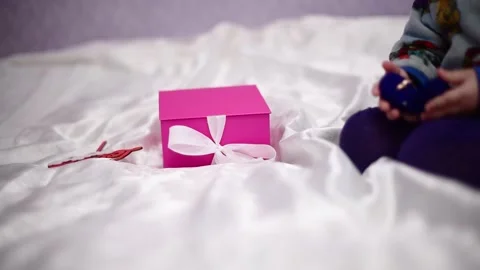 Close-up present pink box and hands of kid playing with blue box with  rings Stock Footage 229868284