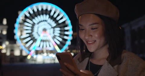 Close up of pretty lady using smartphone while standing at night street Stock Footage 144245544