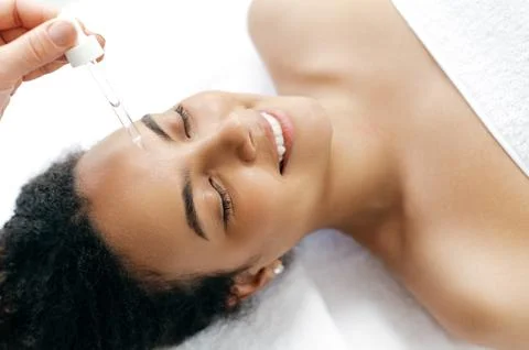 Close-up of a pretty smiling hispanic or brazilian woman, wrapped in a white Stock Photos