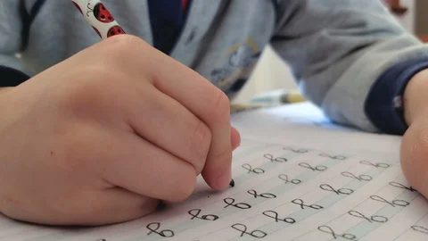Close up of primary school kid doing homework on excercise book,home family life Stock Footage 126984272