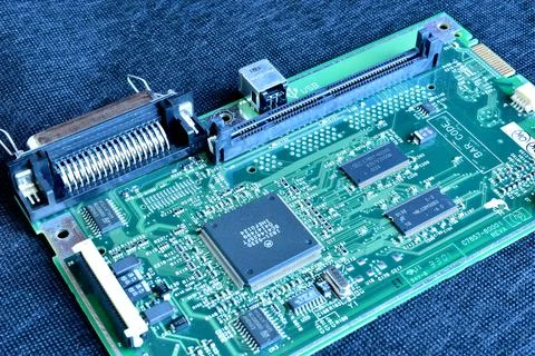 Close-up of a printed circuit board lying on a dark table. Stock Photos