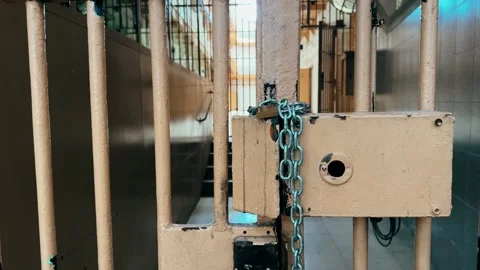Close up of prison bars with locked door and chain in detention, facility Stock Footage 334134642