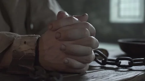 Close up of prisoner hands locked in shackles and folded in prayer 스톡 동영상 339631058