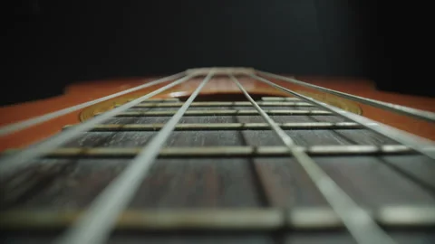 Close-Up Probe Lens Shot Along Guitar Neck and Strings Stock Footage 337998308