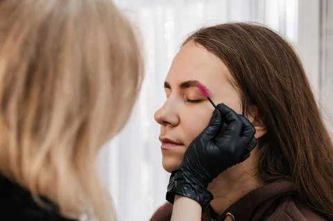 Close-up, the procedure of combing the hairs on the eyebrows in a beauty salo Stock Photos