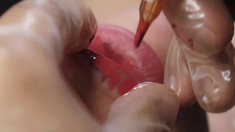 Close-up of the process of applying permanent makeup to the lips. Cosmetology. Stock Footage 312434784