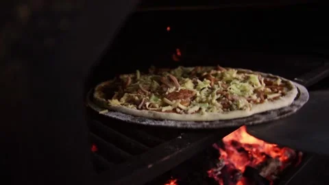 Close up on the process of baking pizza at kitchen. Chef puts the prepared pizza Video stock 149079320