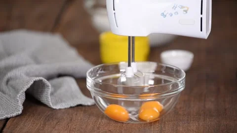 Close-up of the process of beating egg yolks with sugar with electric mixer in a Stock Footage 148123009