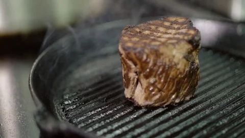 Close-up process of cooking meat juicy appetizing steak on the grill pan Stock Footage 74533523