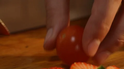 Close-up of the process of cutting cherry tomatoes into quarters with a knife. Stock Footage 123645433