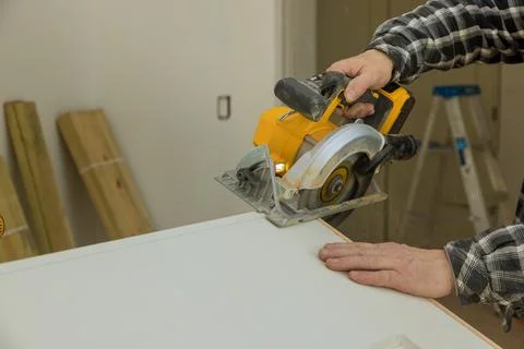 Close Up process cutting of hand circular saw at wood door cuts Stock Photos