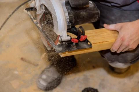 Close Up process cutting of hand circular saw at wood beam cuts Stock Photos