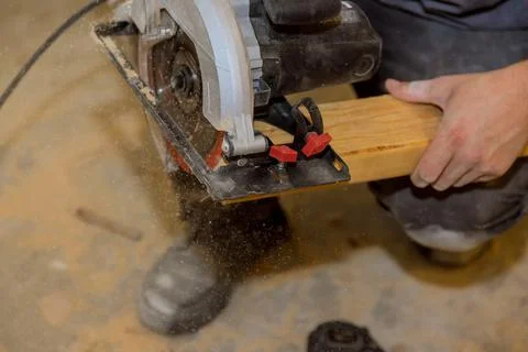 Close Up process cutting of hand circular saw at wood beam cuts Stock Photos