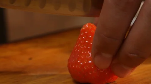 Close-up of the process of cutting strawberry into quarters with a knife. Stock Footage 123779293