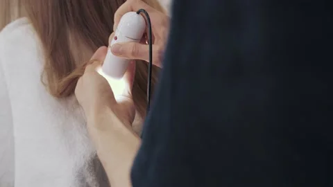 Close-up of the process of diagnosing and treating a girl's long brown hair for Stock-Footage 155739682