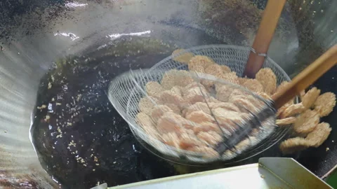 Close-up process of frying crispy rice crackers in the hot oil Stock-Footage 308929471
