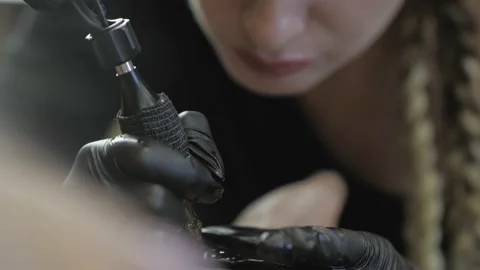 Close-up of the process of getting a tattoo by a tattoo artist. a girl tattoo Stock Footage 139084971