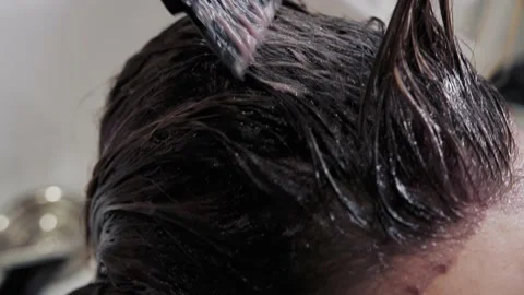 Close-up of the process of highlighting and washing a girl's long brown hair for Stock-Footage 155740788