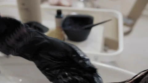Close-up of the process of highlighting and washing a girl's long brown hair for Stock-Footage 155741703
