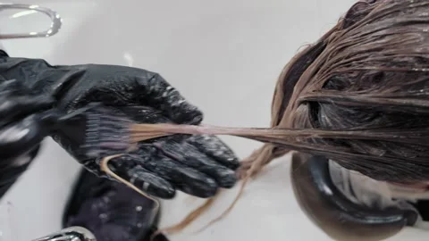 Close-up of the process of highlighting and washing a girl's long brown hair for Stock-Footage 155743434