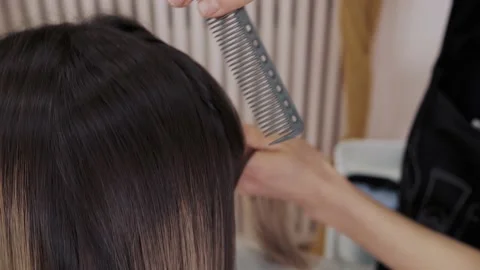 Close-up of the process of highlighting the long brown hair of a girl. The Stock-Footage 155740260