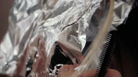 Close-up of the process of highlighting the long brown hair of a girl. The Stock-Footage 155740936