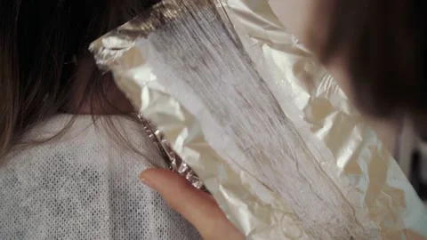 Close-up of the process of highlighting the long brown hair of a girl. The Stock-Footage 155741528