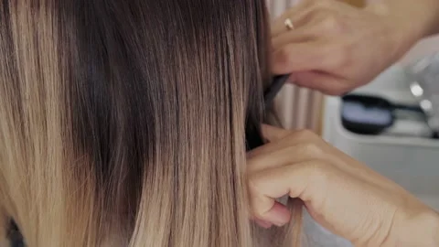 Close-up of the process of highlighting the long brown hair of a girl. The Stock Footage 155742234