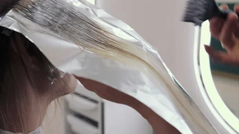 Close-up of the process of highlighting the long brown hair of a girl. The Stock-Footage 155742802