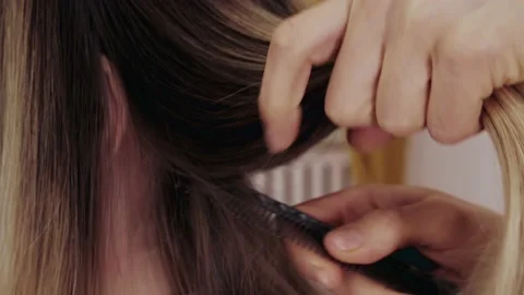 Close-up of the process of highlighting the long brown hair of a girl. The Stock-Footage 155743151